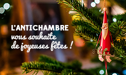Photo d'une guirlande du Père Noël accrochée dans un sapin. Texte : L'Antichambre vous souhaite de joyeuses fêtes !
